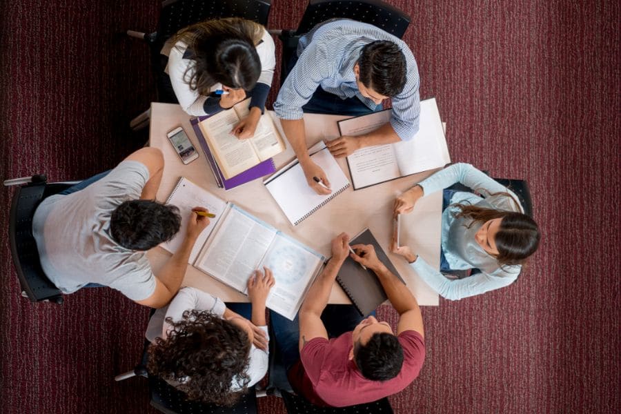 grupo de estudiantes en una mesa realizando actividades