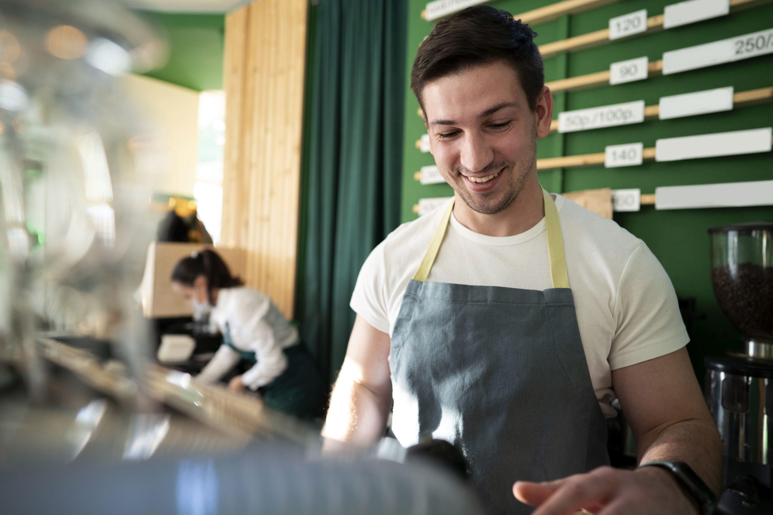 chico trabajando de camarero tras la barra
