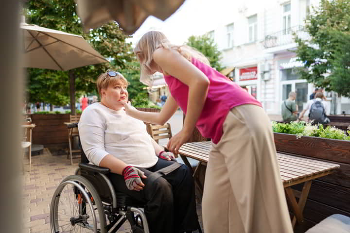 técnica sociosanitaria dando un paseo con una persona dependiente