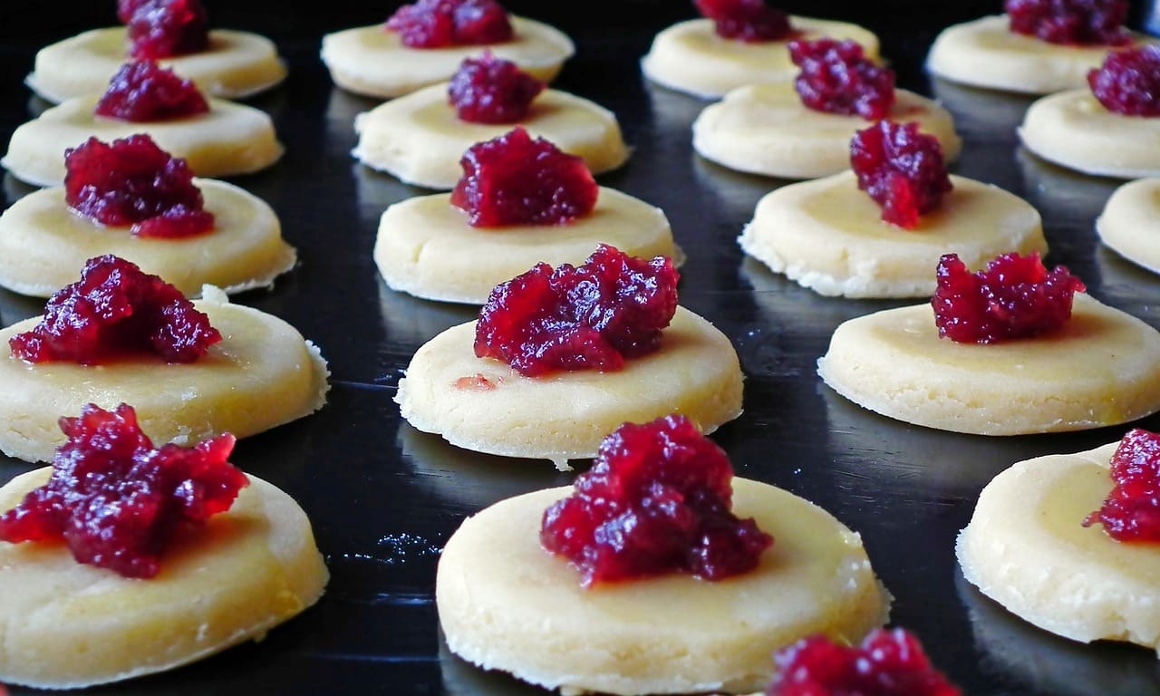 pastelillos con mermelada en una bandeja, listos para hornear